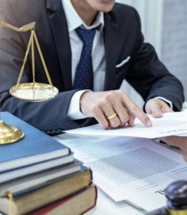 A trust litigation lawyer with a client going over a case, showing evidence of a conflict of interest, which is a violation of trustee duties in California.