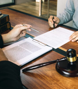 A lawyer going over a trust document with a beneficiary to review the duties of a trustee in California that their fiduciary must uphold.