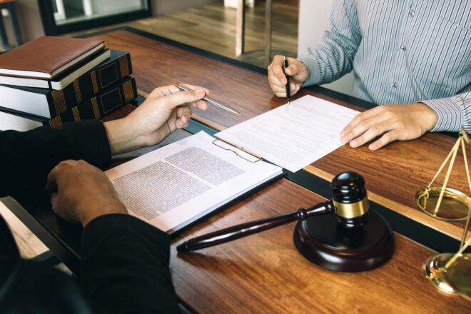 A lawyer going over a trust document with a beneficiary to review the trustee duties in California that their fiduciary must uphold.