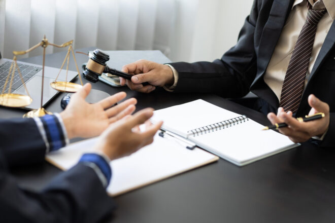A trust litigation lawyer going over a case with a client who is pursuing legal action because a fiduciary violated his or her trustee duties in California.