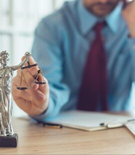 A lawyer reviewing a case and preparing for probate litigation in Orange County with a miniature sculpture of Lady Justice and scales in the foreground.