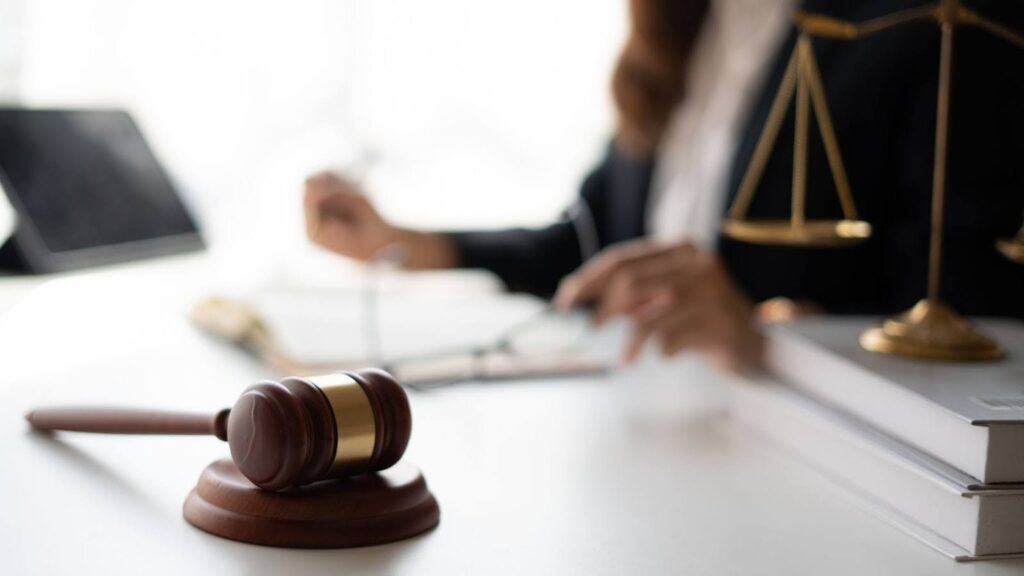 A gavel with a lawyer in the background working on a case that revolves around the question, Can an executor be removed in California?